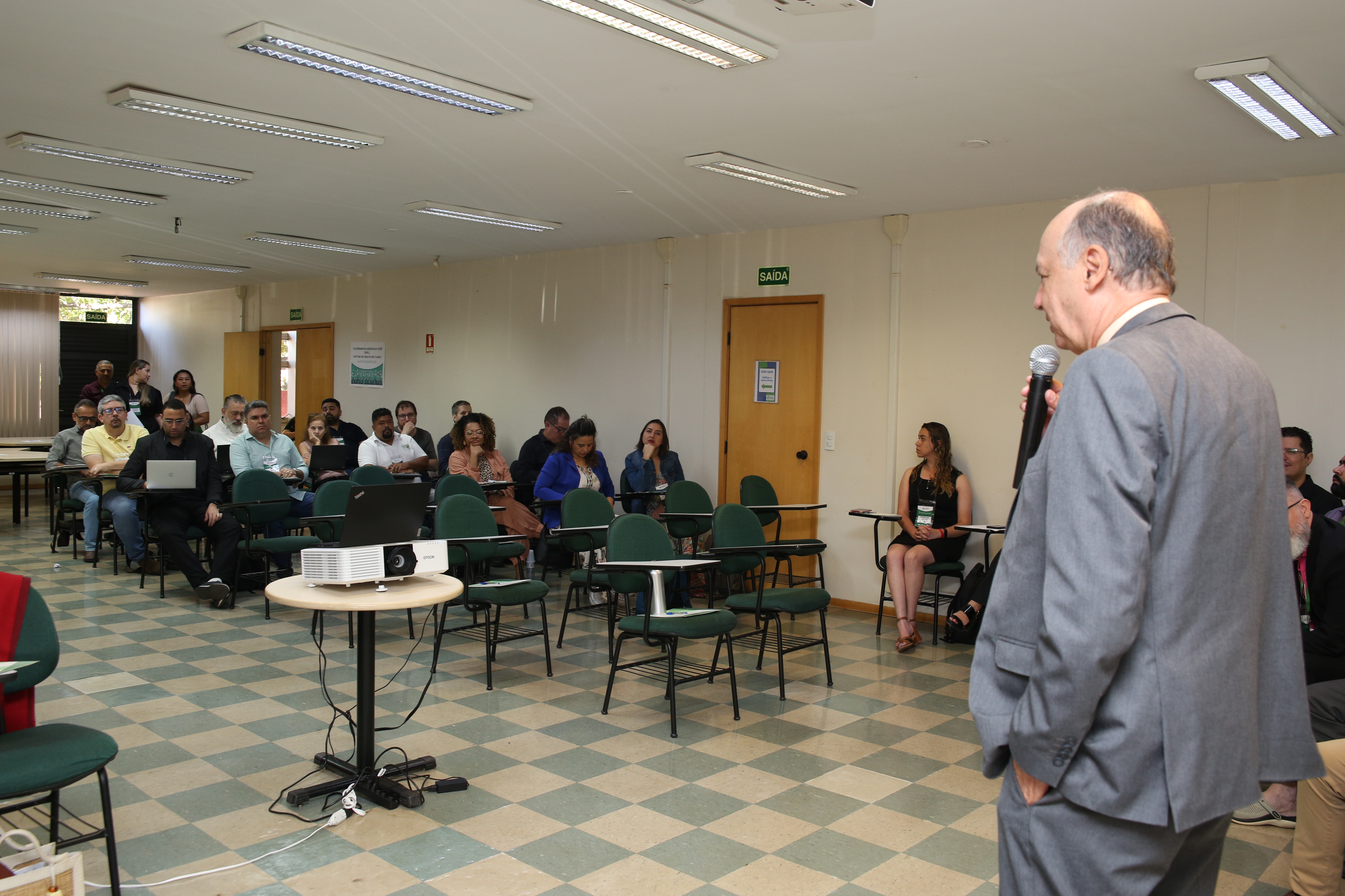 Vice-presidente do CFMV, Rômulo Spinelli, falando ao microfone. A plateia está sentada, ouvindo a apresentação.