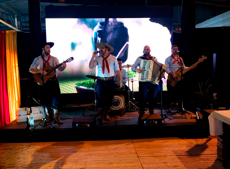 Banda usando vestimentas típicas gaúchas se apresentando.