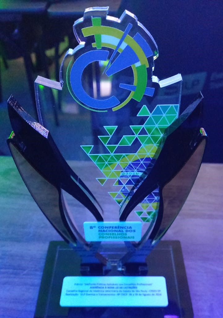 Prêmio da oitava conferência nacional dos conselhos profissionais. A escultura é feita de vidro nas cores preta e transparente, com parte da bandeira do brasil estampada em triângulos.