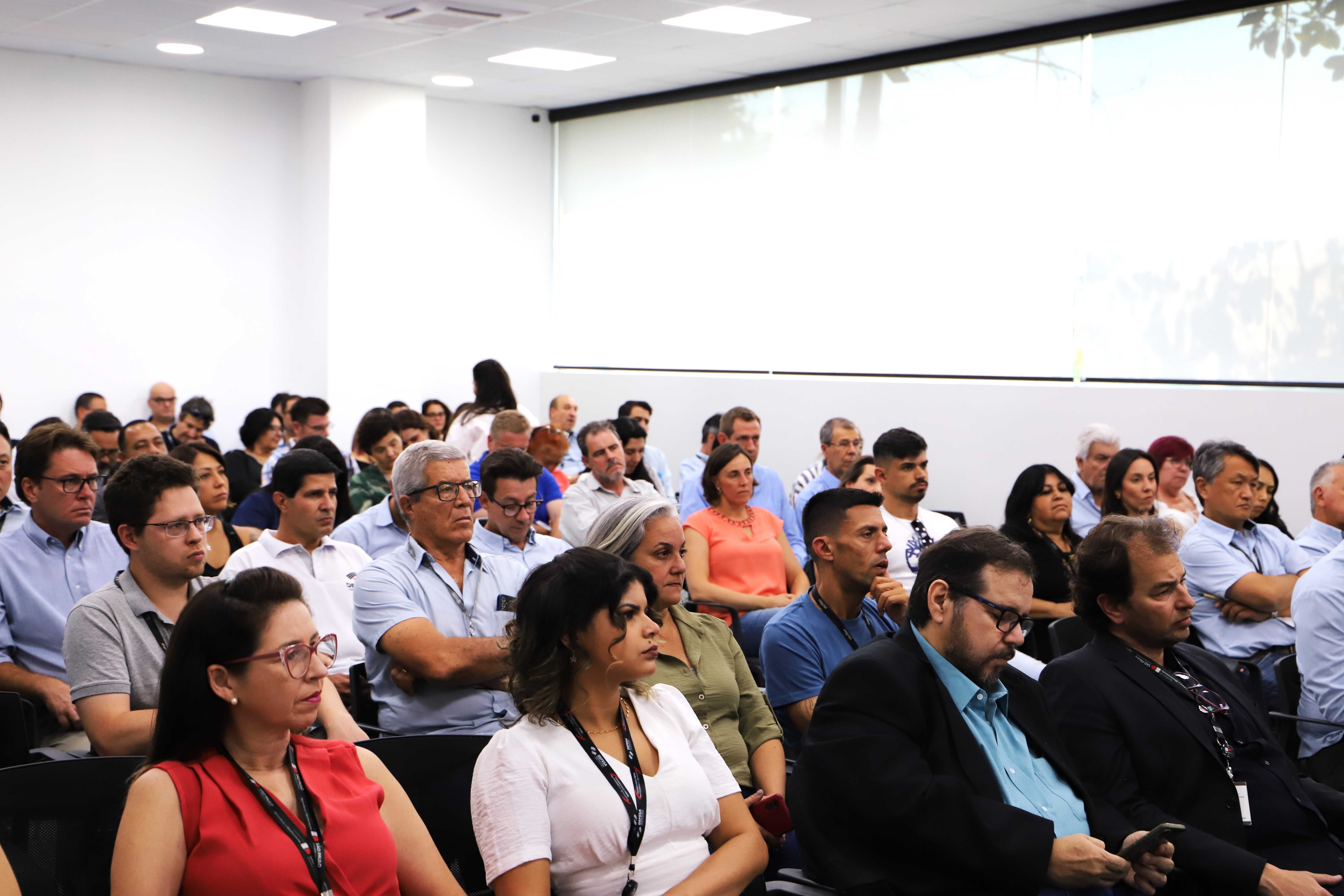 Pessoas sentadas em fileiras de um auditório assistindo o evento.