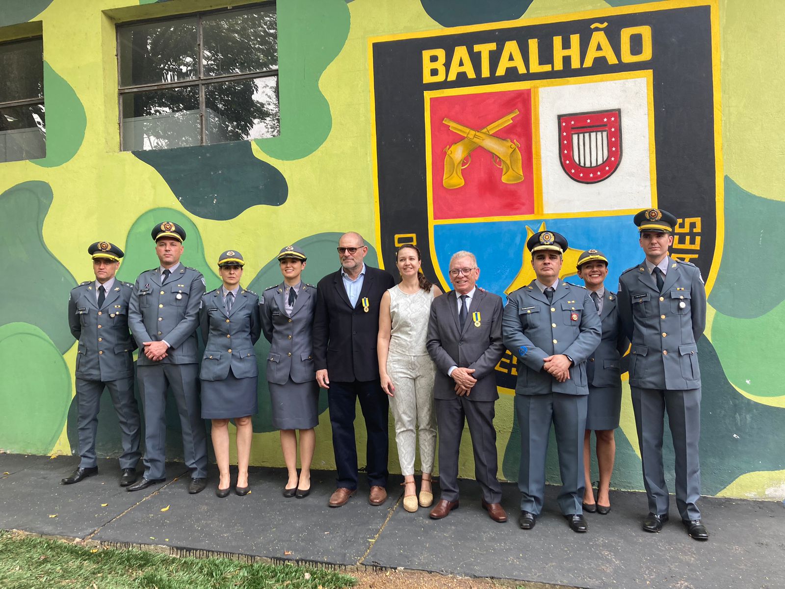 Oficiais do batalhão junto da presidente em pé pousando para foto.
