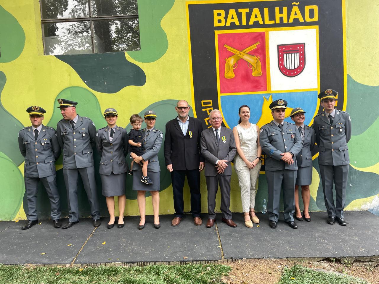 Homens e mulheres de fardas reunidos sendo homenageados.