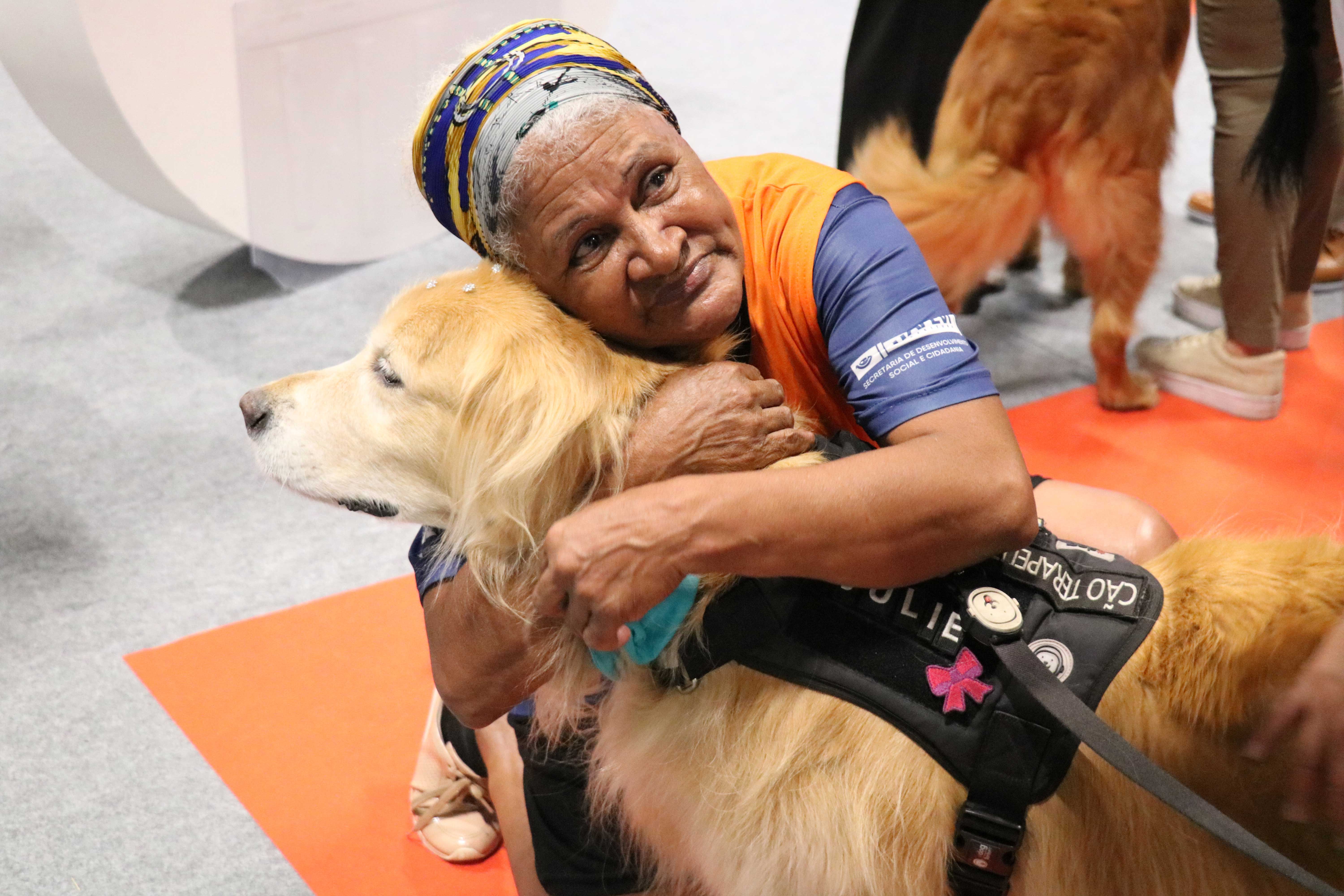 mulher idosa abraçando cão