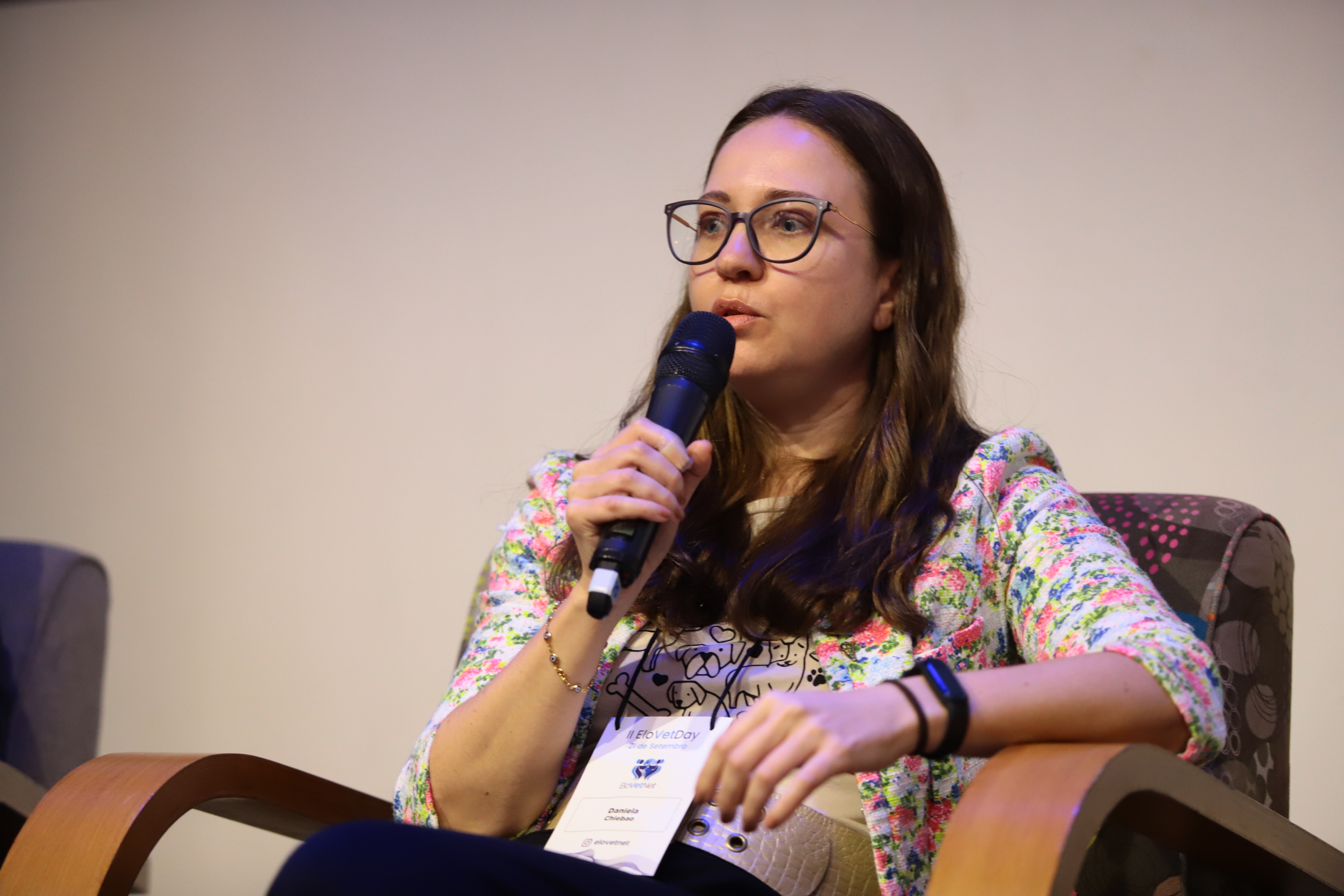 A presidente do CRMV-SP, Daniela Chiebao, sentada com um microfone na mão