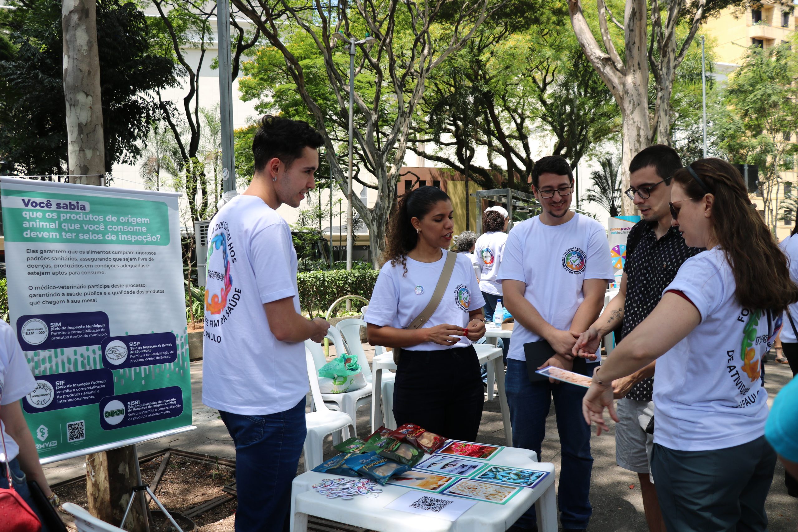 Pessoa falando sobre temas da caravana da saúde enquanto outros observam.