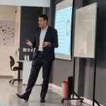 Homem falando em palestra.