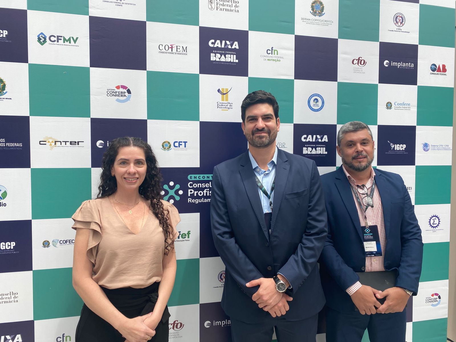 Homens e mulher posando para foto.