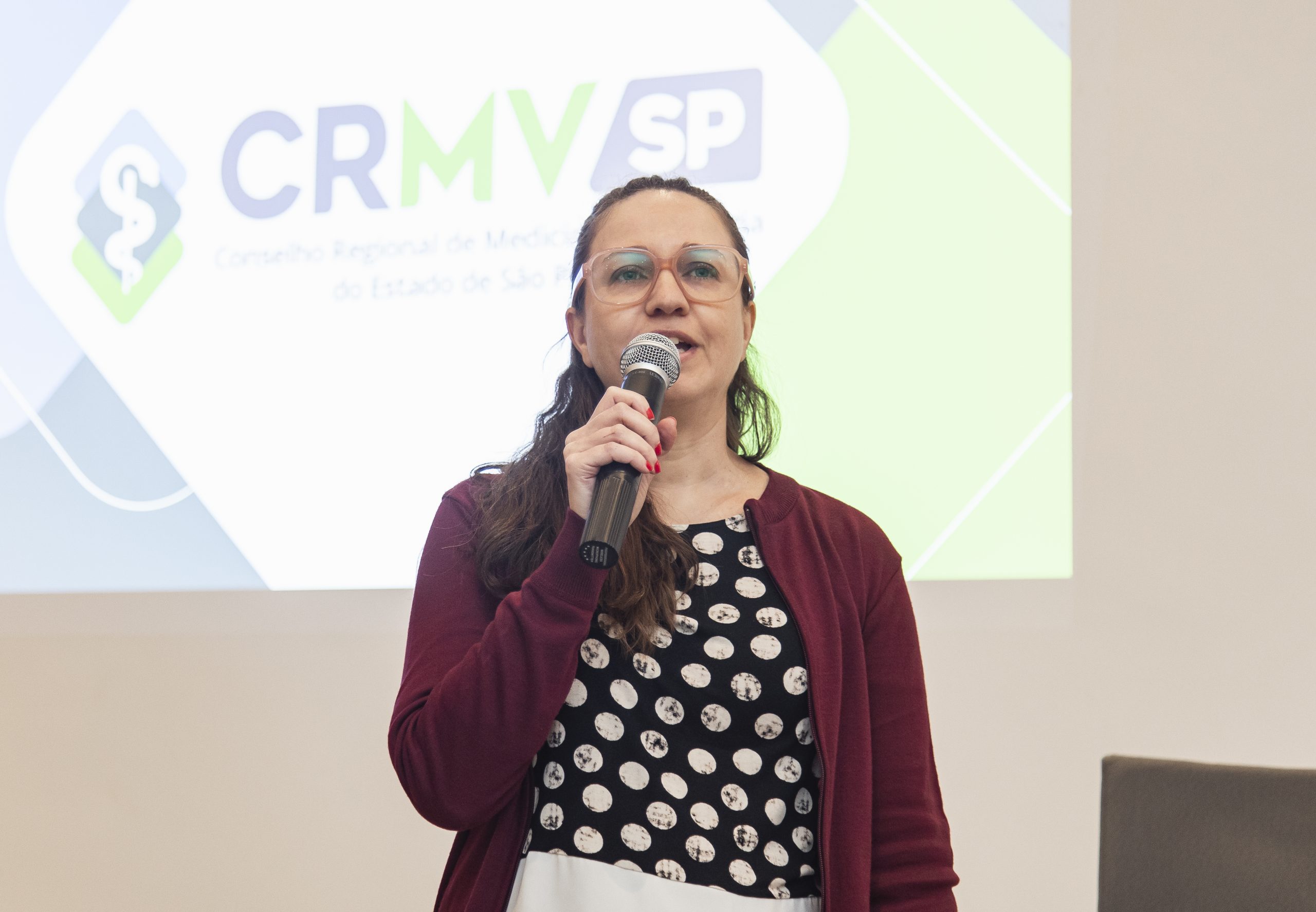 mulher falando no microfone para público