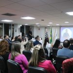 Com o auditório da sede lotado, ao fundo, no púlpito, o premiado discursa em agradecimento.