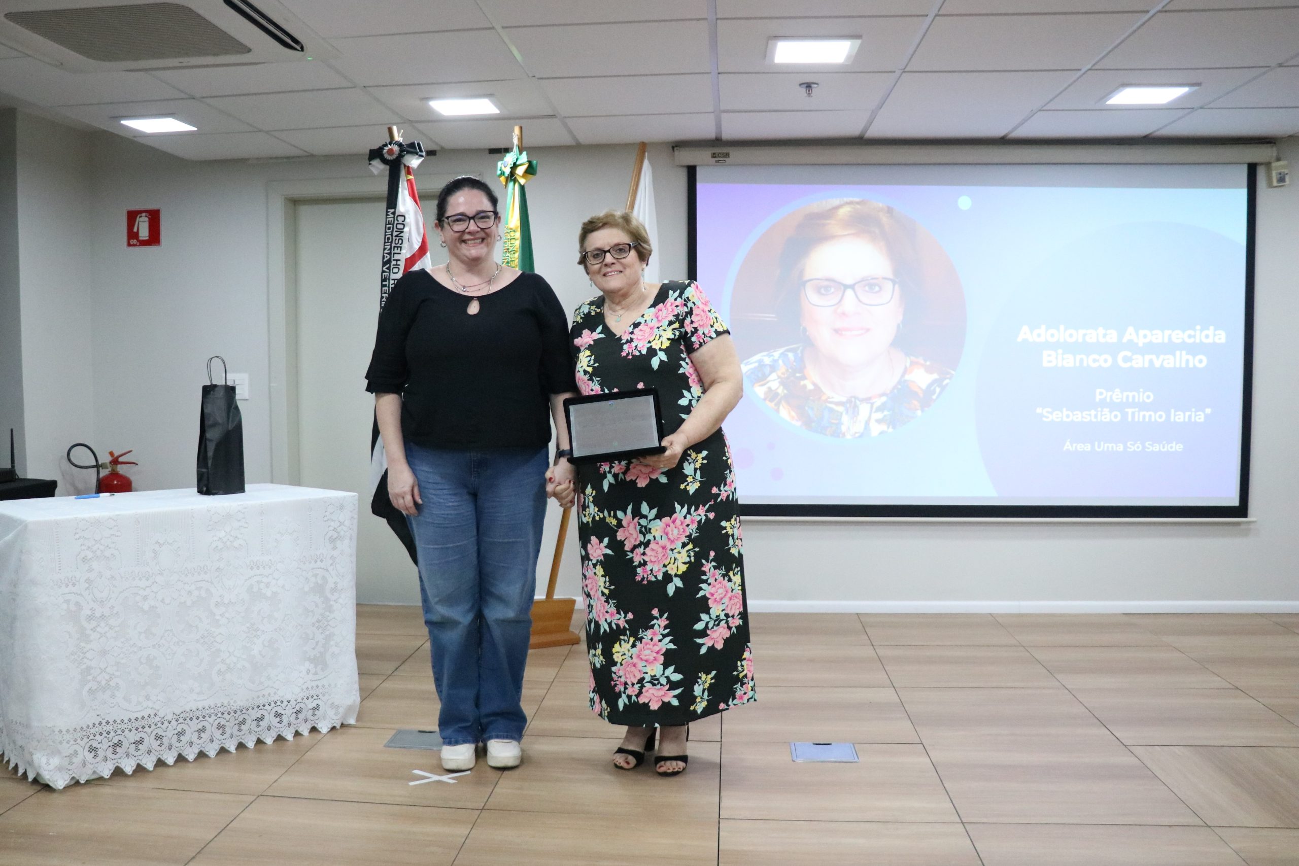 A secretária-geral do CRMV-SP entrega a placa à premiada na categoria Uma Só Saúde.