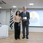 A vice-presidente do CRMV-SP entrega a placa ao premiado na categoria Zootecnia.