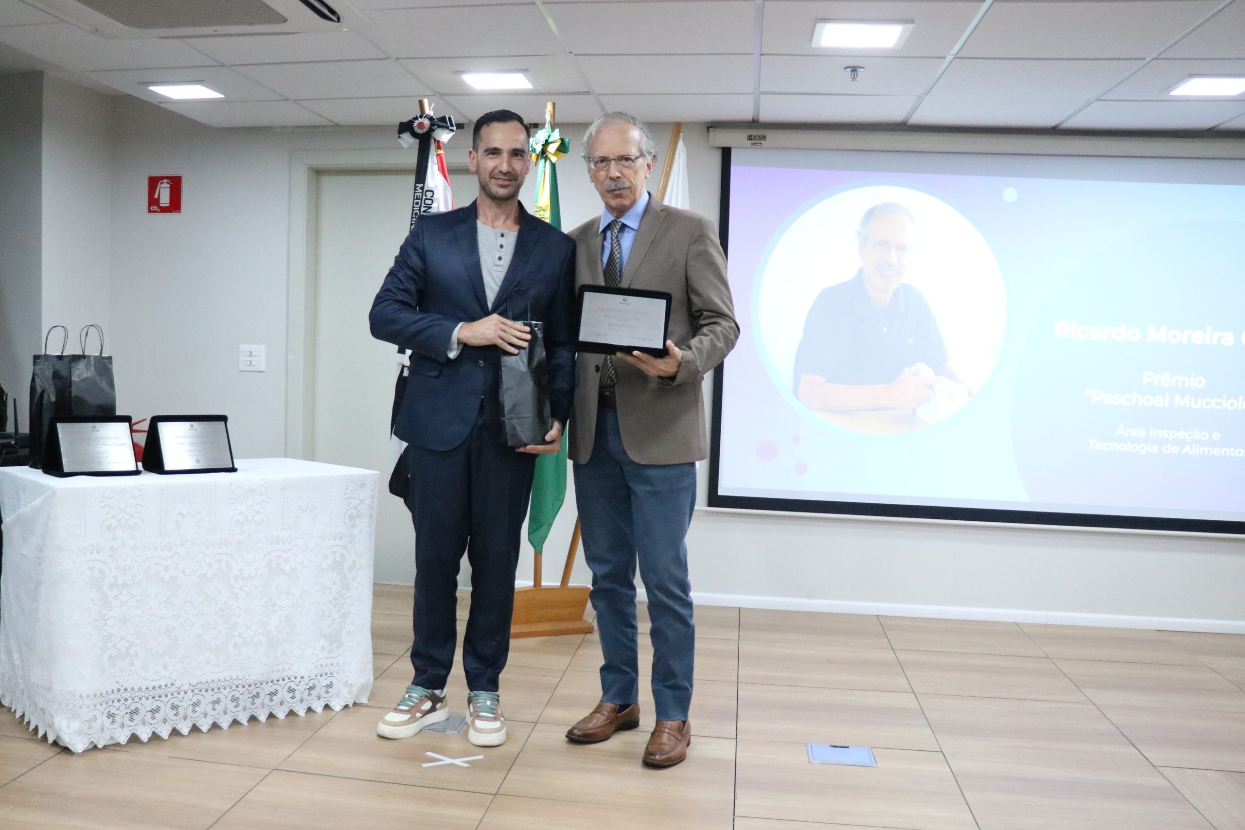 Tesoureiro do CRMV-SP entrega placa para o premiado na categoria Inspeção e Tecnologia de Alimentos.