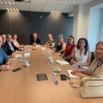 Pessoas sentadas em mesa sorrindo para foto em reunião co Procon.