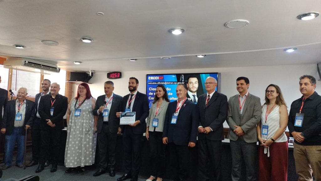 Homens e mulheres posando para foto em evento.