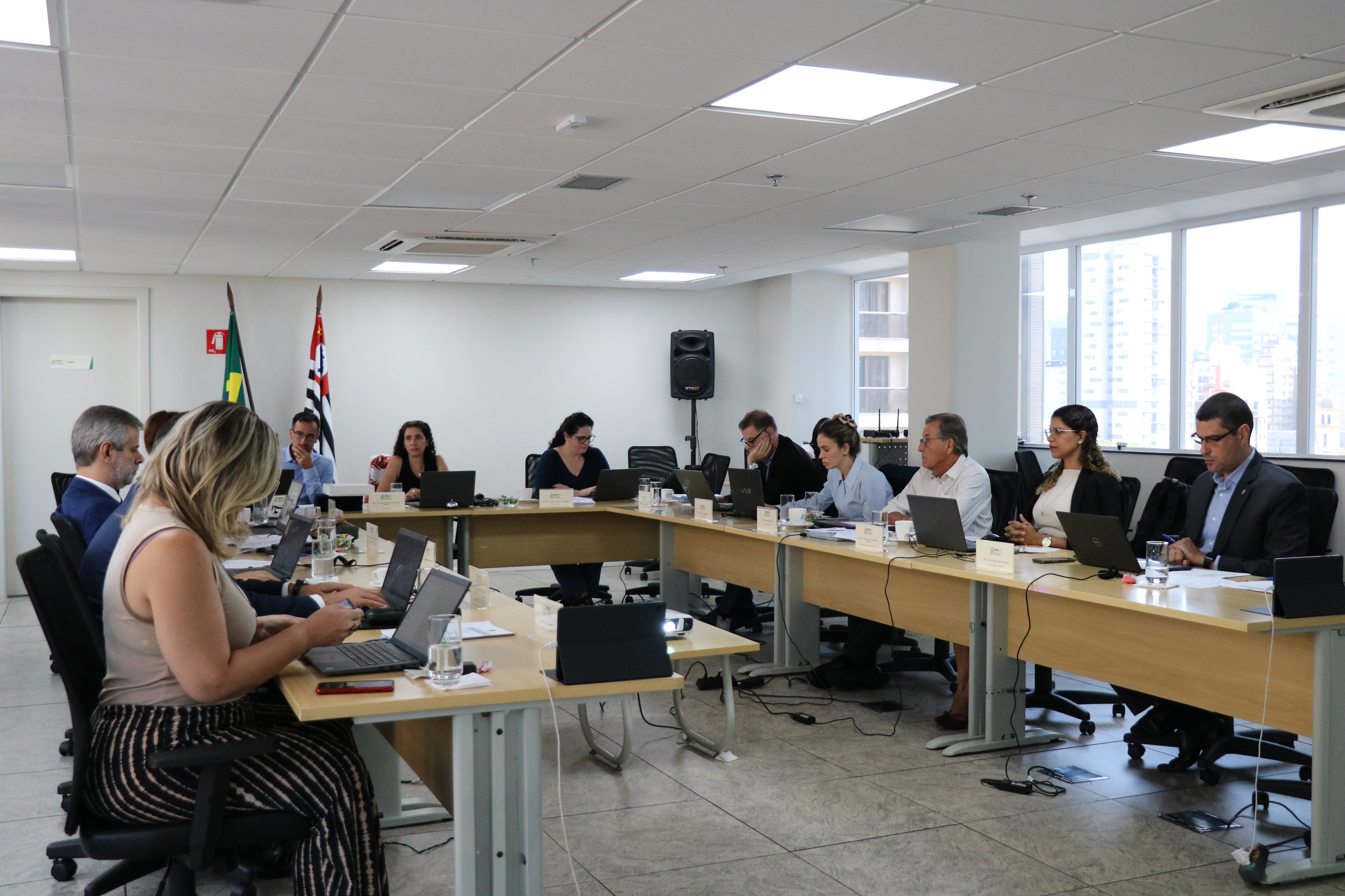 Pessoas sentadas em mesa durante reunião.