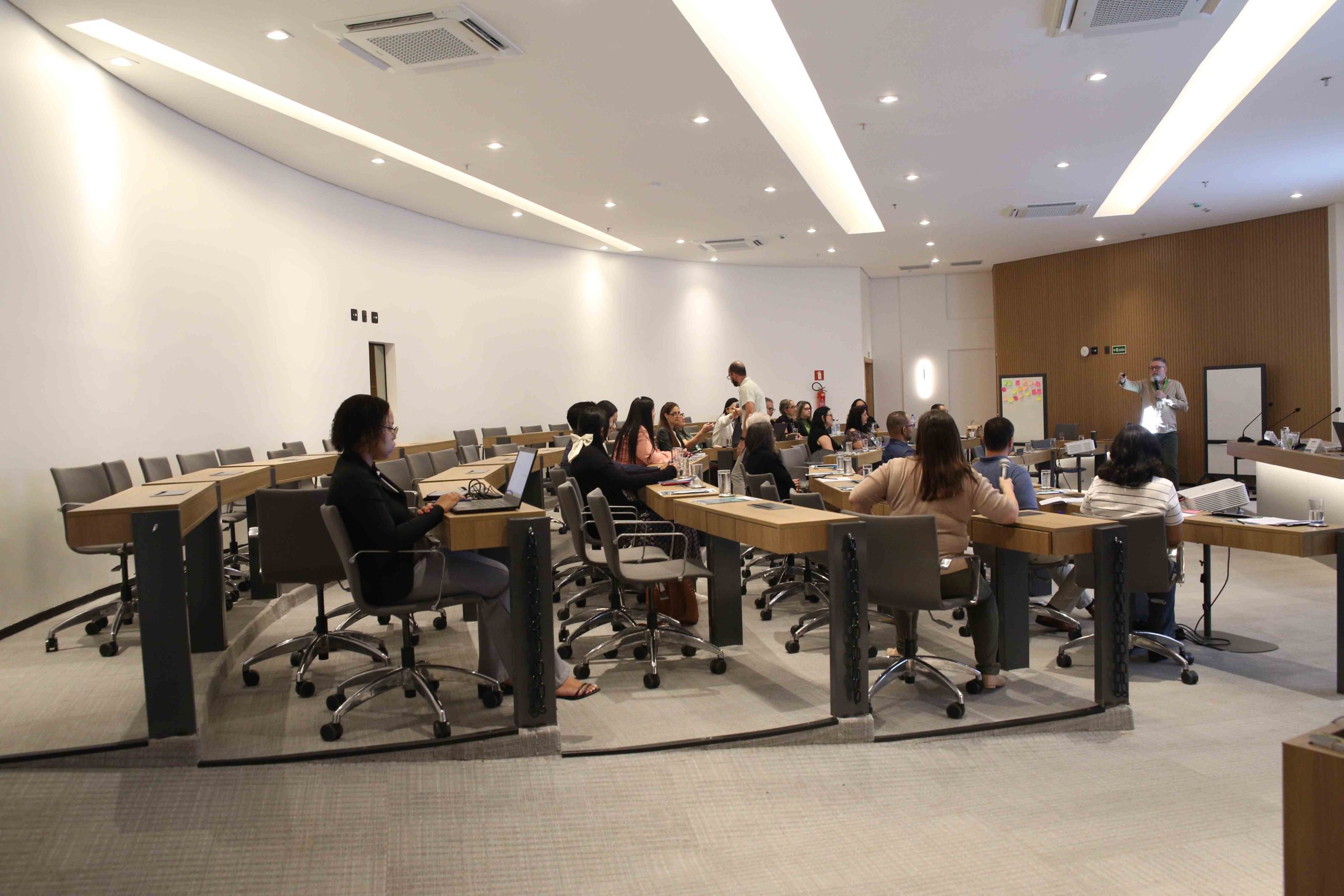 Pessoas sentadas na bancada assistindo a apresentação.