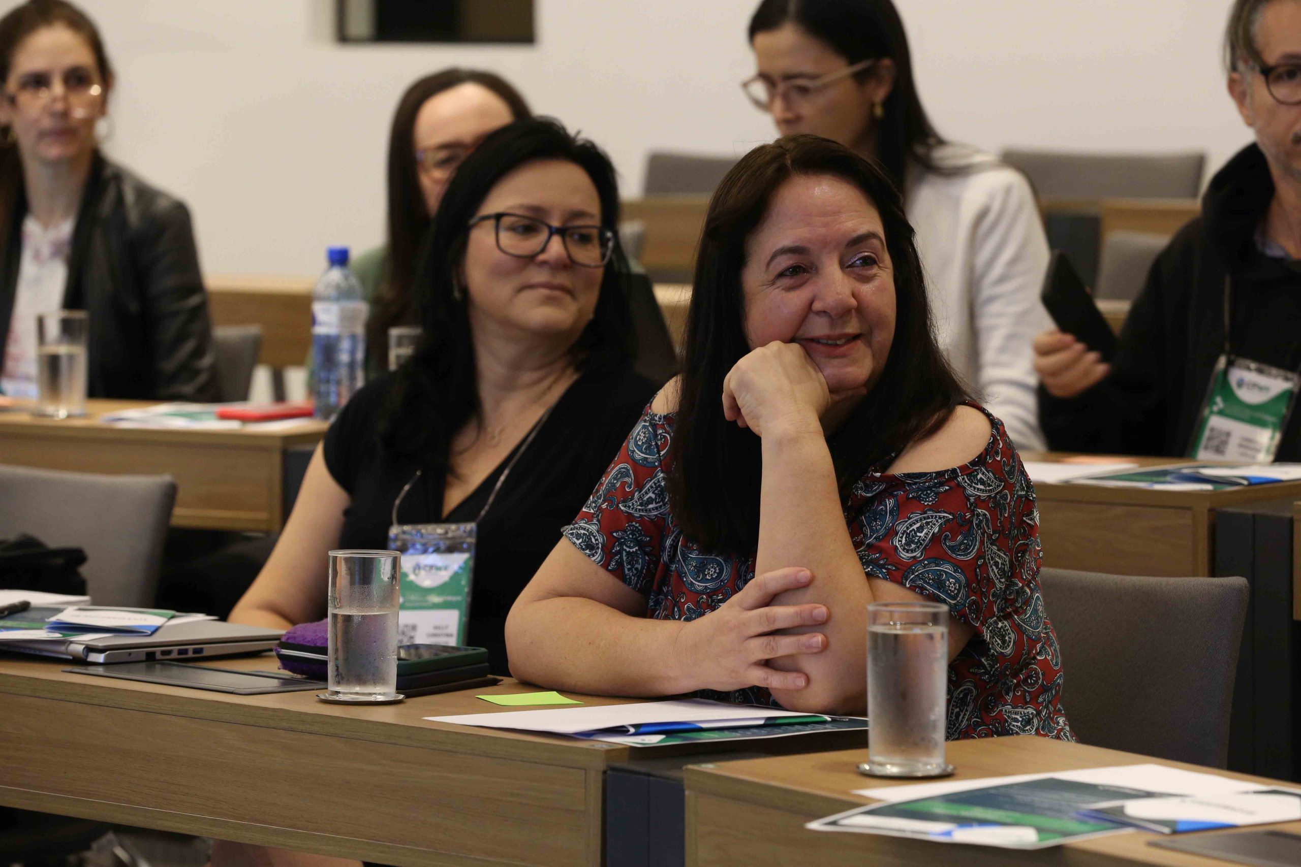 Em destaque: mulher branca de fios lisos pretos e médios, é a coordenadora de atendimento e registros, Geni da Silva.