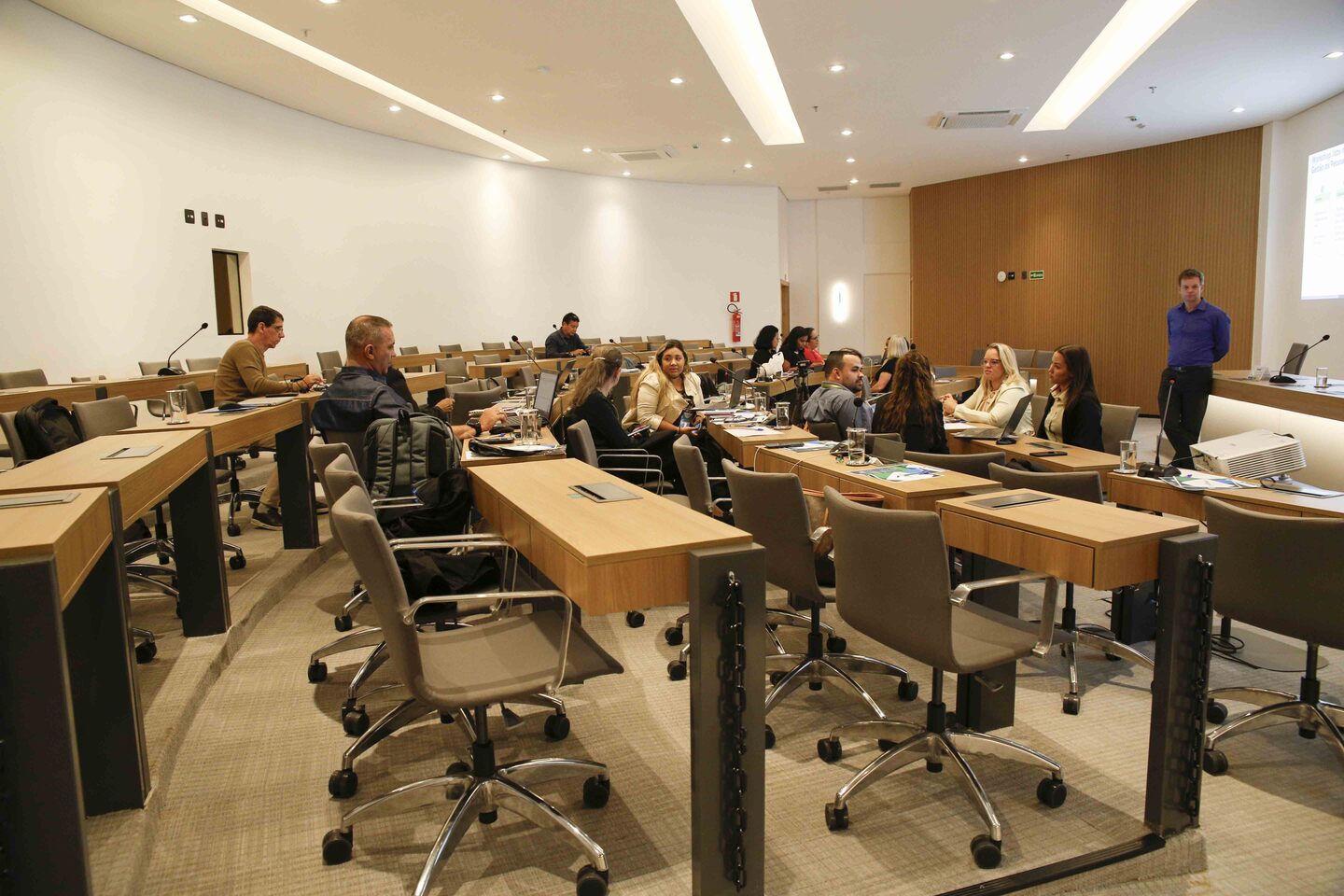Pessoas sentadas frente a apresentação.