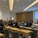 Pessoas sentadas olhando apresentação.