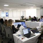 Pessoas em reunião assistindo a outro palestrante.