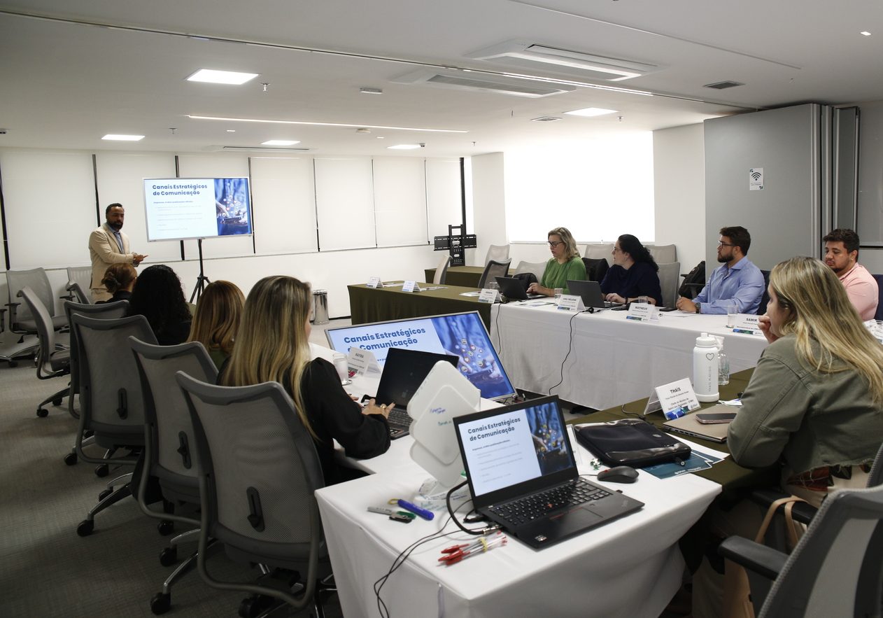 Pessoas em reunião assistindo a outro palestrante.