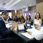 Pessoas sentadas a mesa discutindo pautas.