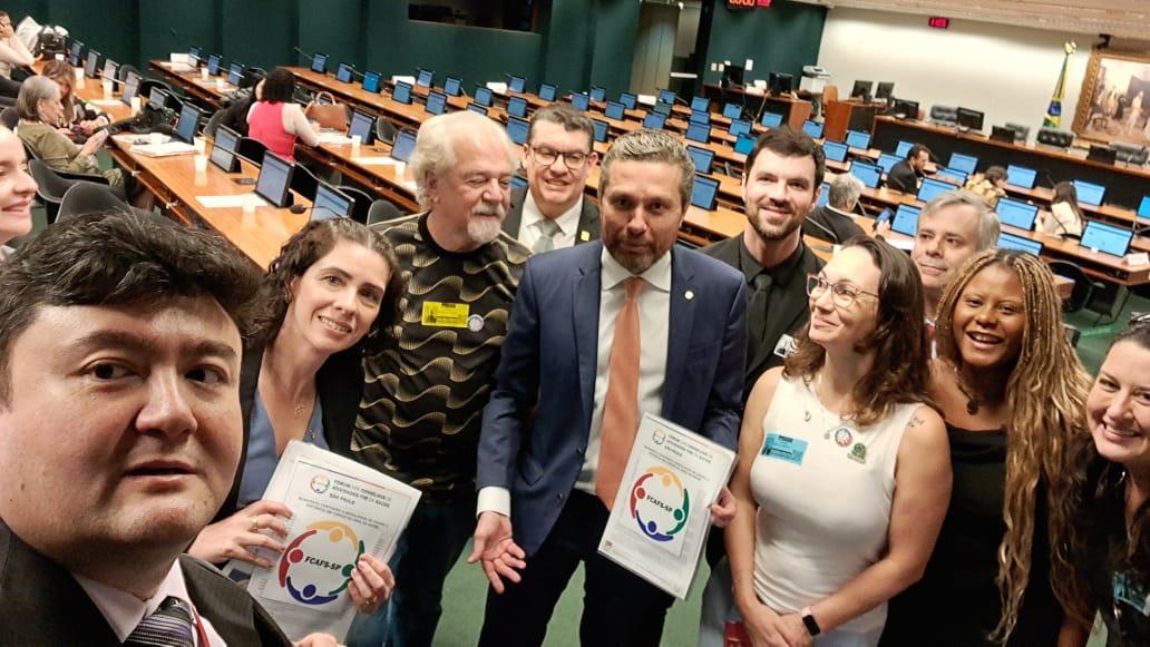 Pessoas em pé reunidas para foto com deputado federal.