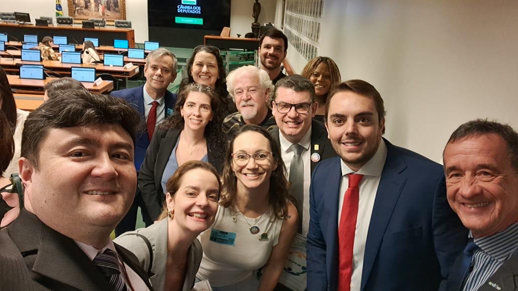 Pessoas em pé reunidas para foto com deputado federal, Felipe Francischini.