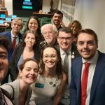 Pessoas em pé reunidas posando para foto.