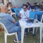 Homens sentados na mesa em frente ao computador.