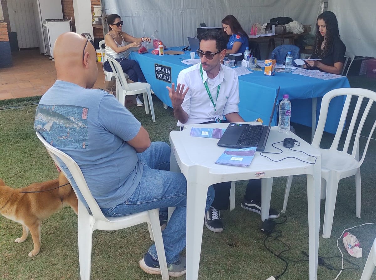 Homens sentados na mesa em frente ao computador.