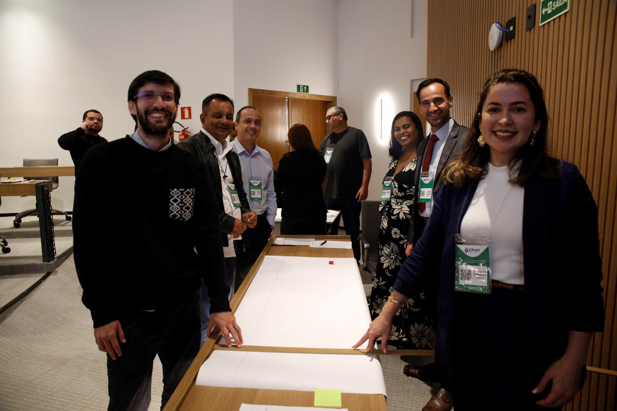 Pessoas em frente umas as outras em uma mesa posando para foto.