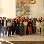 Pessoas em pé reunidas para foto geral.