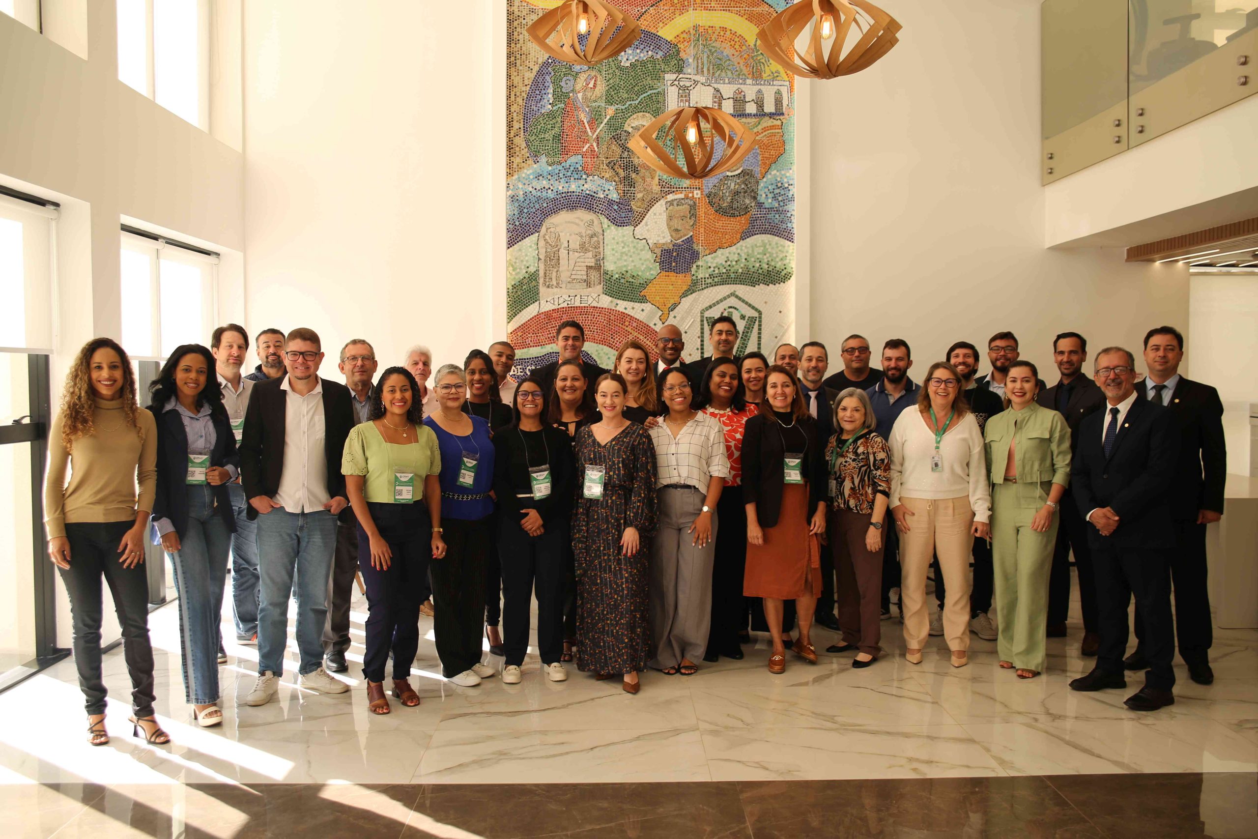 Pessoas em pé reunidas para foto geral.