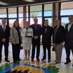 Na foto, Isabela Oliveiro Consentino posa ao lado do vice-presidente do CFMV e dos presidentes e representantes dos regionais presentes ao evento: o vice-presidente do CRMV-RJ, Julio Israel; a presidente do CRMV-AL, Annelise Nunes; o conselheiro do CRMV-SP, Martin Jacques Cavaliero; a presidente do CRMV-PE, Maria Elisa Araújo; e o presidente do CRMV-RJ, Diogo Alves.