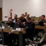 Pessoas sentadas assistindo a apresentação.