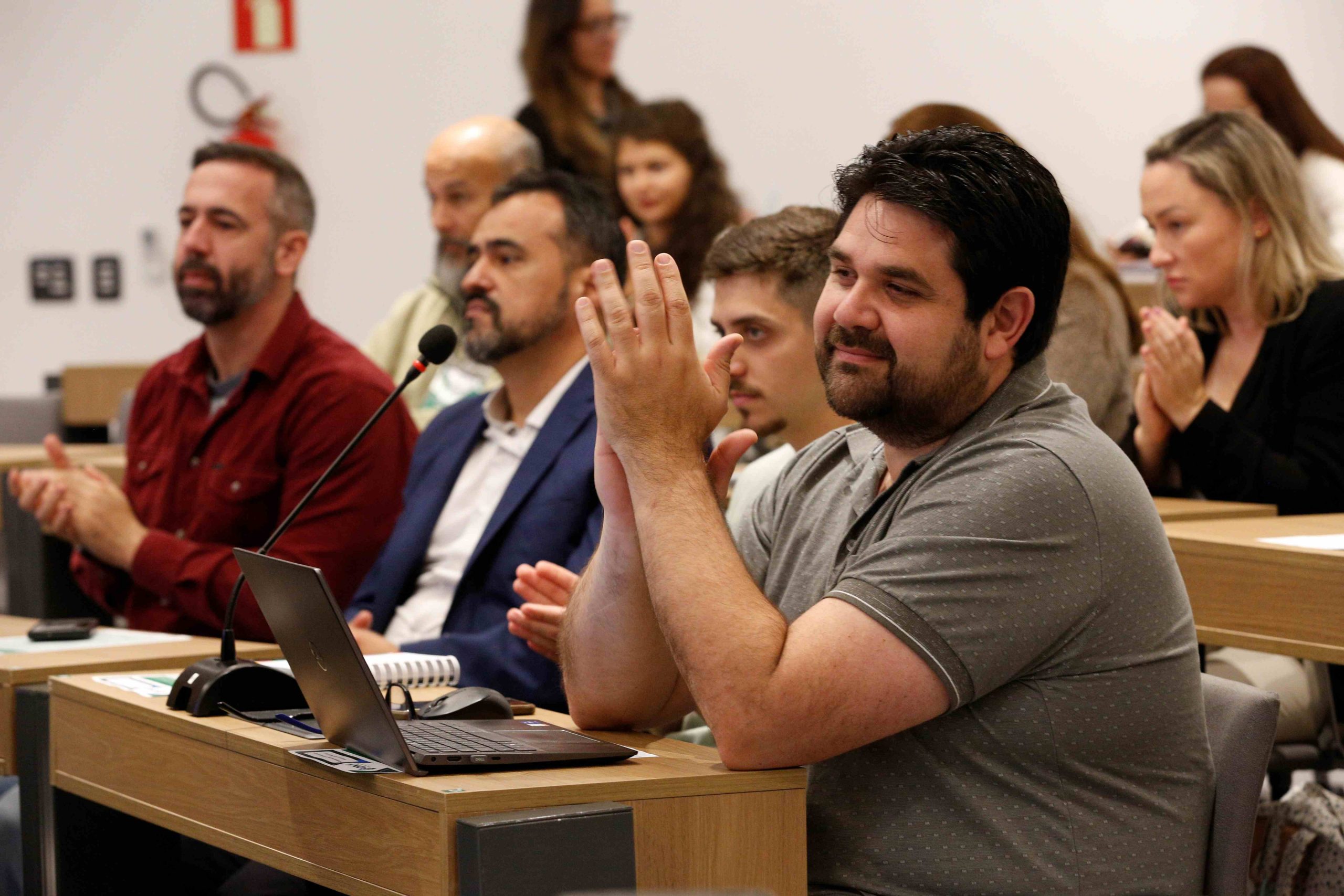 Pessoas sentadas assistindo a apresentação. Em destaque: Fabrício Braga Rassy.