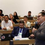 Visão do palco de pessoas assistindo a uma palestra.