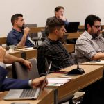 Pessoas sentadas assistindo a uma apresentação.