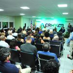 Fundo de um auditório cheio, à direita, há pessoas em pé e na frente membros da nova Diretoria do CRMV-MA.