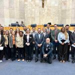 Pessoas reunidas posando para foto em espaço amplo.