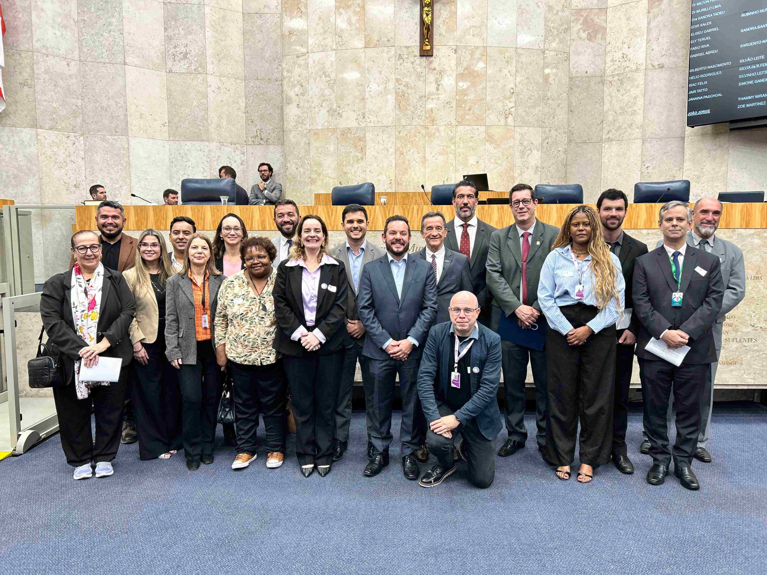 Pessoas reunidas posando para foto em espaço amplo.