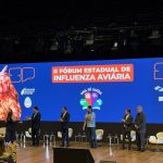 Pessoas reunidas no palco para apresentação durante segundo fórum estadual de influenza aviária..