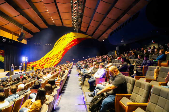 Pessoas sentadas para apresentação.