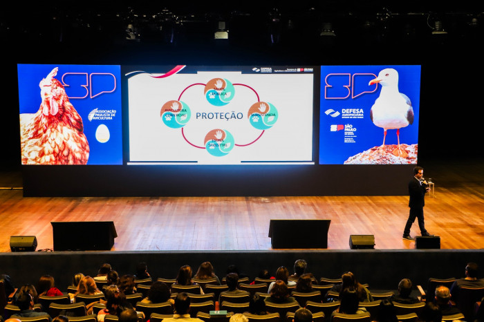 Homem frente ao público palestrando durante segundo fórum estadual de influenza aviária.