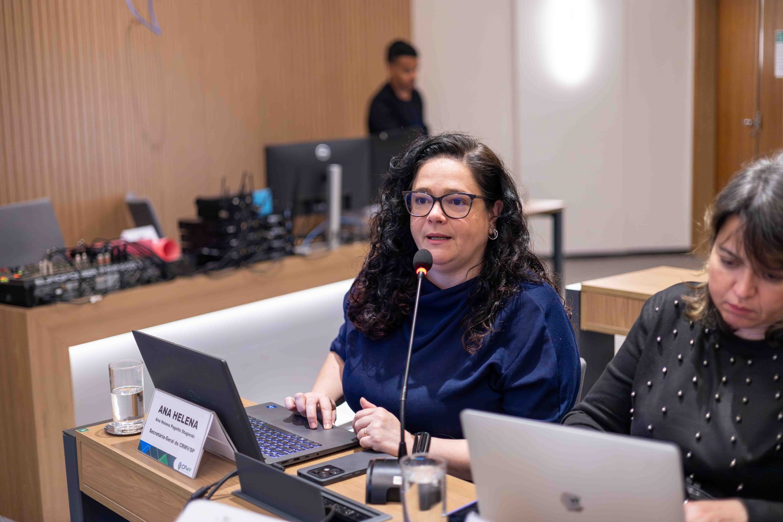 Mulher de óculos falando ao microfone. Essa é a secretária-geral do CRMV-SP Ana Helena Pagotto Stuginski.