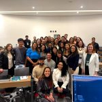 Pessoas reunidas com palestrante para foto.