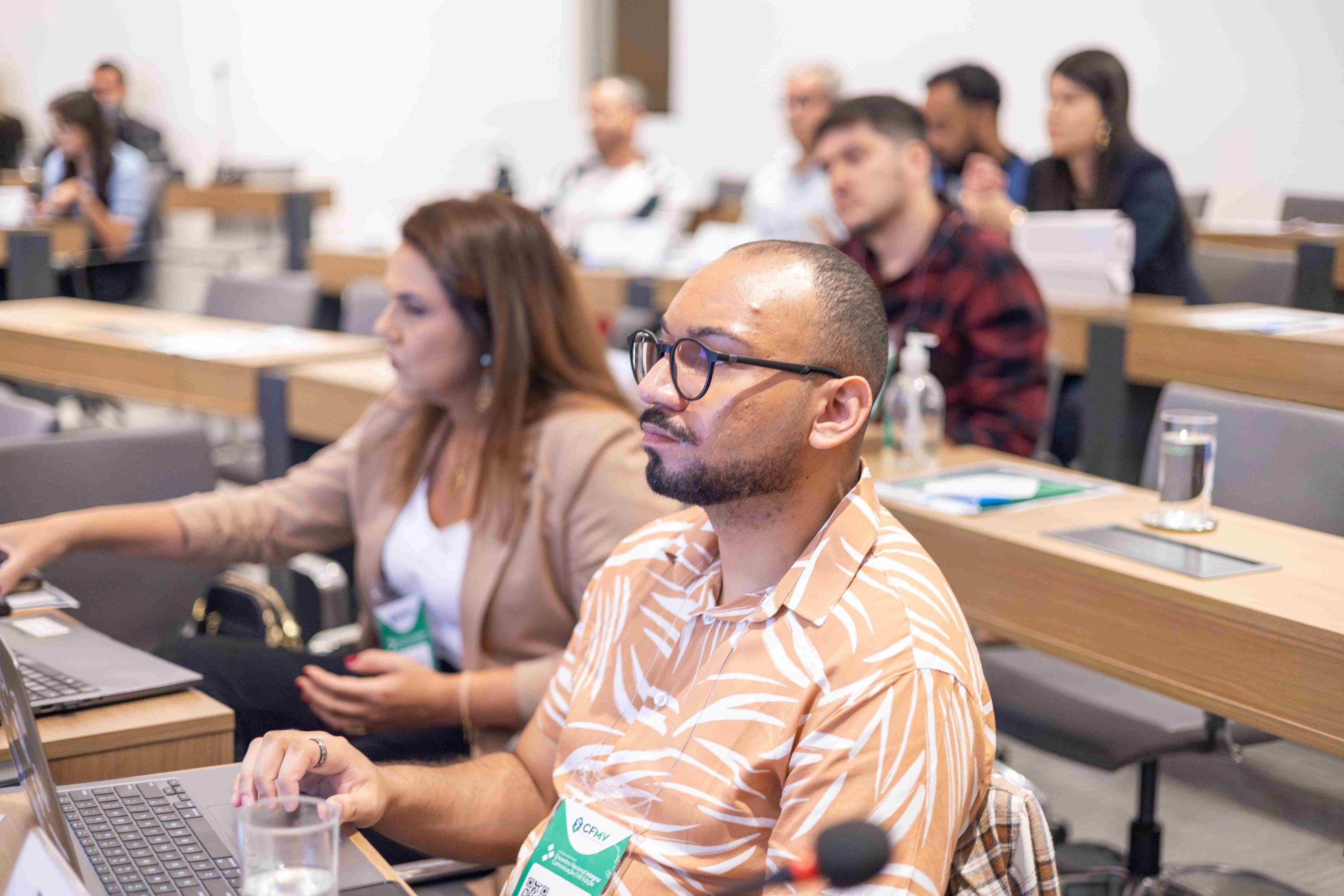Homem careca, de óculos e barba usando o computador.