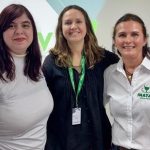 Três mulheres, no meio; a presidente do CRMV-SP, Daniela Pontes Chiebao, vestindo blusa azul marinho folgada com botões no meio entre duas mulheres de camisa branca representantes da Inataa.