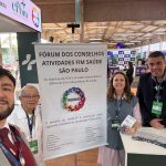 Três homens e uma mulher posando para foto com a placa do Fcafs.